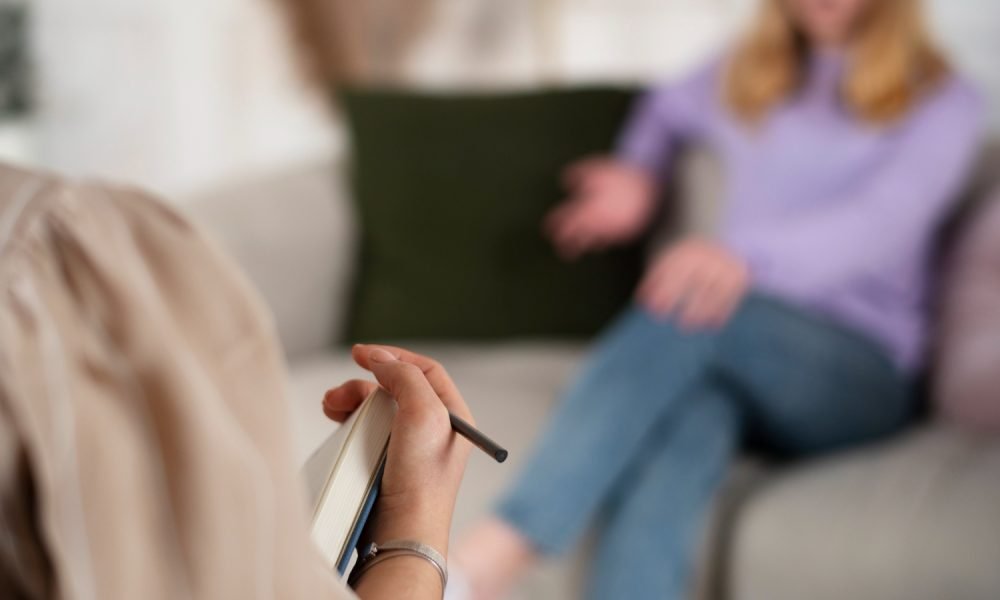 Psicólogo a conversar com paciente num ambiente calmo.