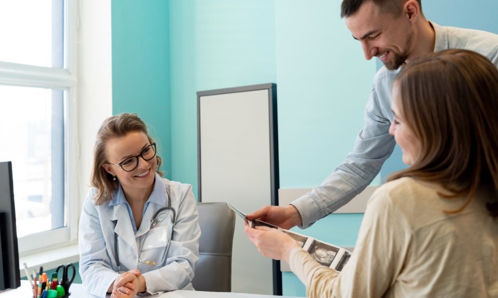 Médica a atender paciente num consultório.