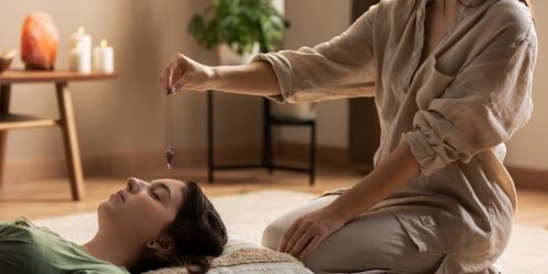 Terapeuta a realizar massagem num espaço tranquilo.