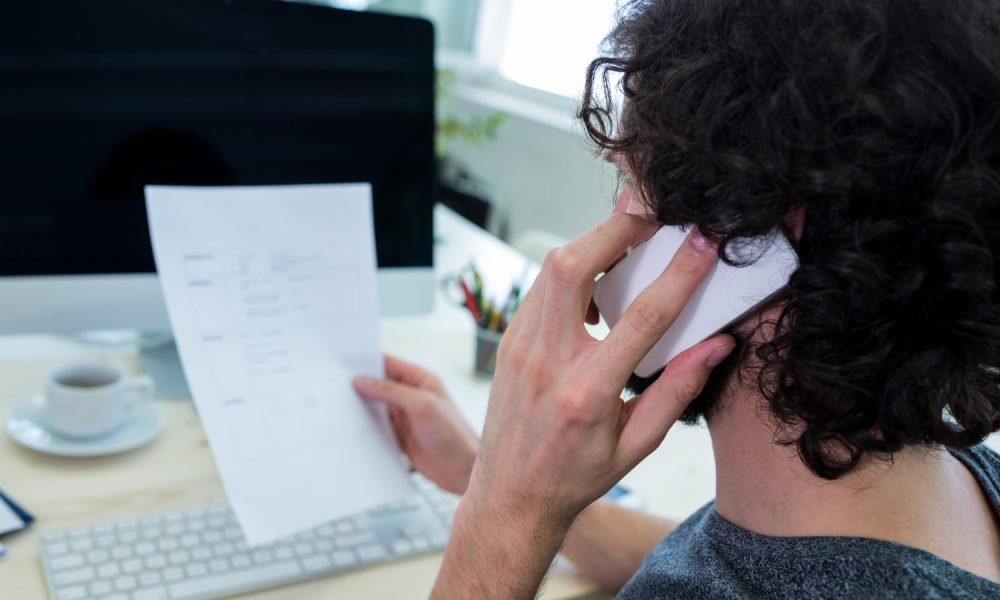 Pessoa a preencher um formulário com apoio técnico.