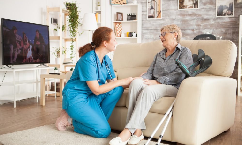 Enfermeira a aplicar tratamento a paciente sentado.