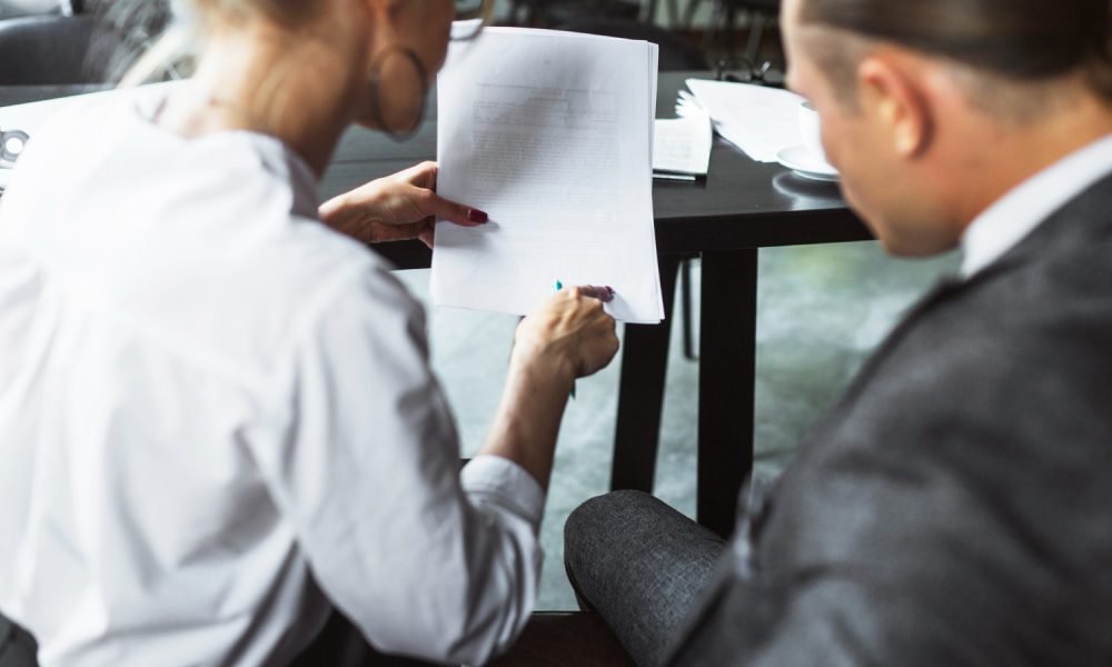 Advogado a explicar cláusulas de um contrato a um cliente.